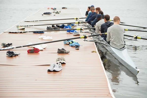 A group of people are in a boat ready to row.