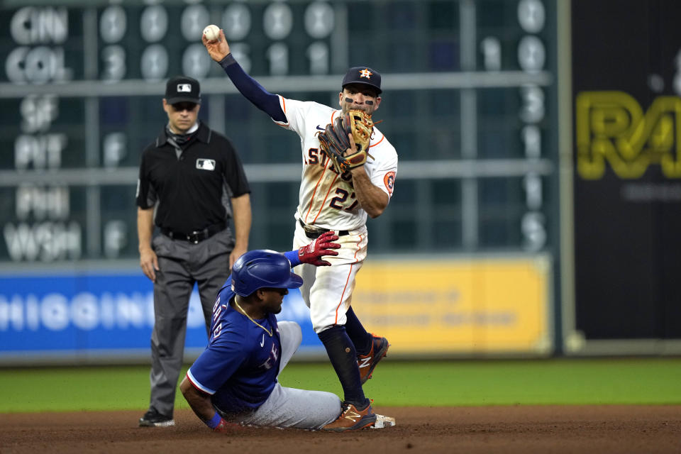Houston Astros second baseman Jose Altuve (27) throws first for a double play as Texas Rangers' Andy Ibanez slides into second base during the 10th inning of a baseball game Thursday, May 13, 2021, in Houston. Ibanez was out at second and Khris Davis was out at first on the double play. (AP Photo/David J. Phillip)