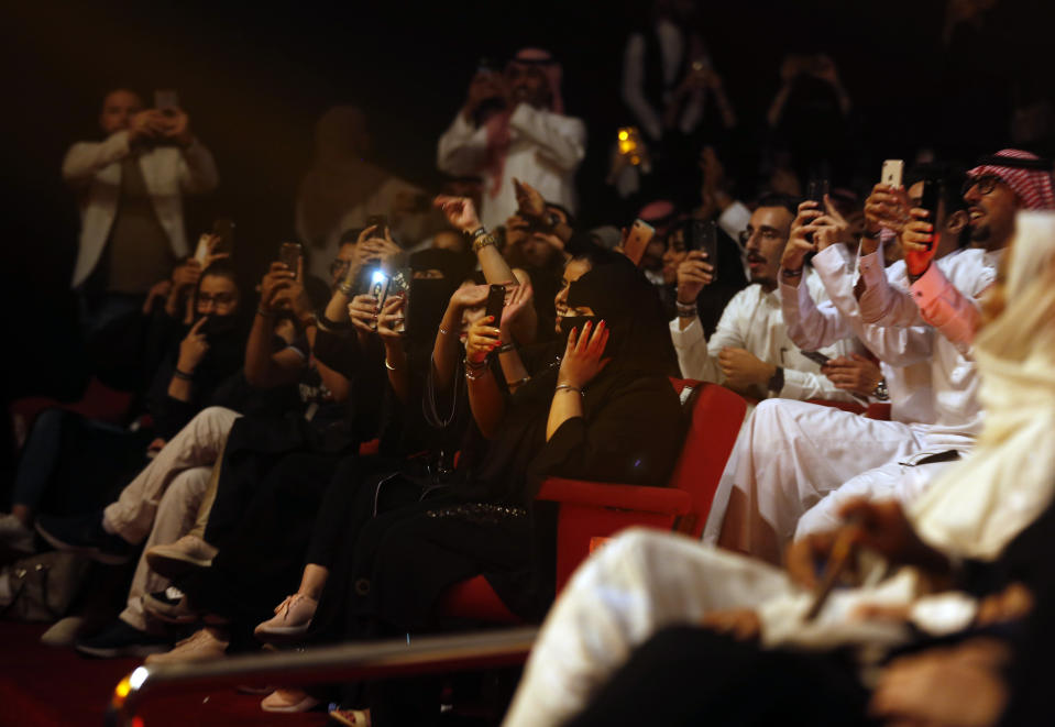 In this Thursday, Aug. 22, 2019 photo, Saudi tourists film the well-known Iraqi singer, Kazem al-Saher as he performs during the al-Soudah festival in Abha, southwest Saudi Arabia. The scenes of women zip lining and young Saudis at concerts, in a remote village nonetheless, are a stark departure from ultraconservative policies that for decades barred concerts and gender mixing, and shunned women’s sports in the kingdom. (AP Photo/Amr Nabil)