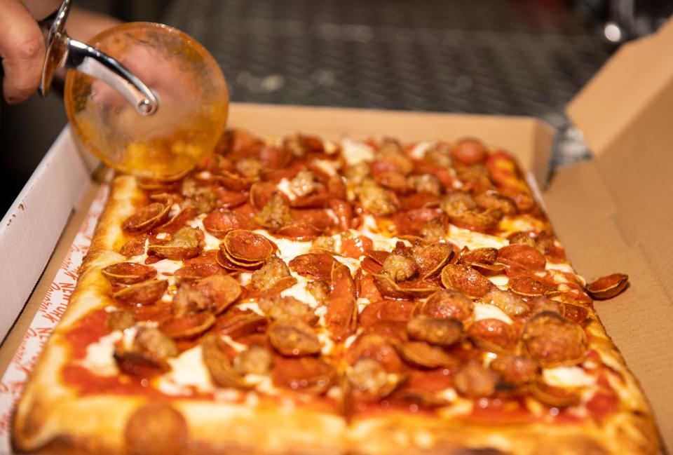 Owner Mike Galatioto cuts a Sicilian-style pizza at New York Squares at the 45th Parallel Brewing, Friday, July 7, 2023, in Independence, Ore.