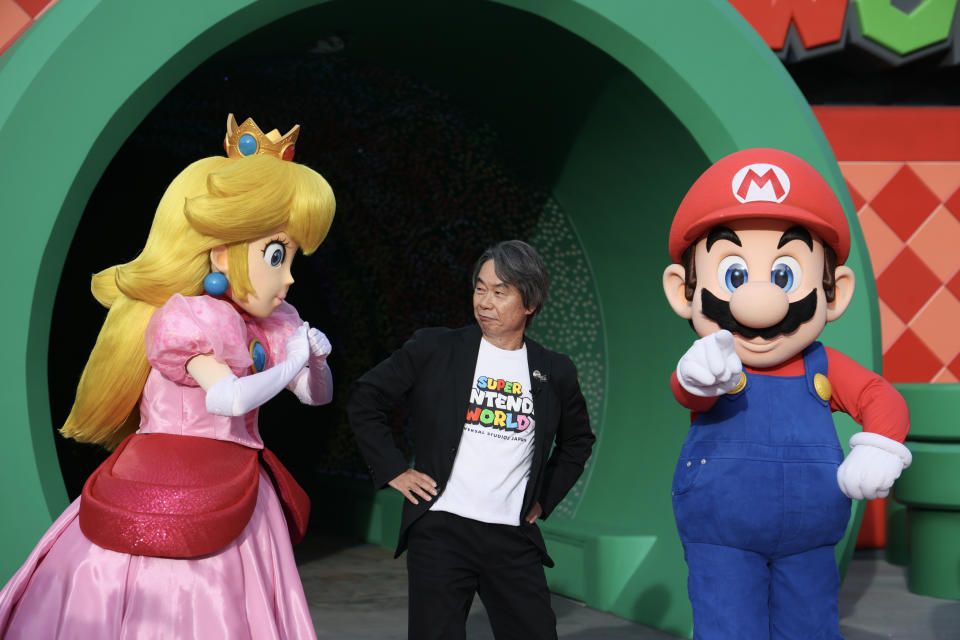 Erfinder Shigeru Miyamoto zwischen seinen Figuren Mario und Princess Peach bei der Eröffnung von 