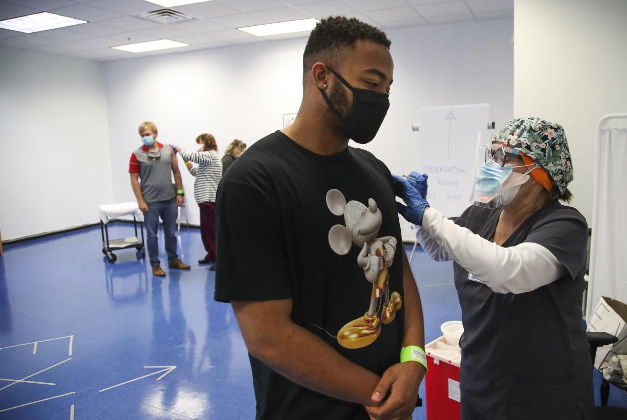 Matthew Dickens, 21, left, from St. Petersburg, gets his first vaccine as it was administered by RN Arlene Keys, at the Central Pinellas vaccine site in Largo, Fla. on Monday, April 5, 2021. "Quick and easy, I barely felt it," Dickens said. "I was in and out." Floridians 18 and over can now get the Pfizer, Moderna or Johnson & Johnson vaccines, while 16- and 17-year-olds will be able to get the Pfizer shot.