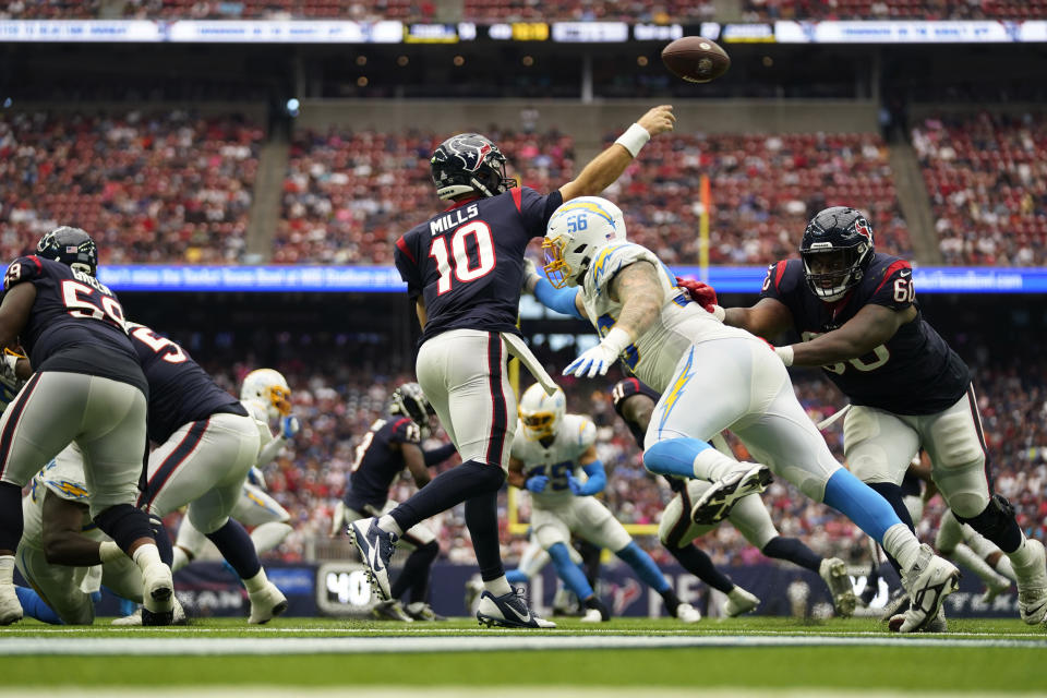 Houston Texans quarterback Davis Mills (10) is pressured by Los Angeles Chargers defensive end Morgan Fox (56) as he throws during the second half of an NFL football game Sunday, Oct. 2, 2022, in Houston. (AP Photo/Eric Christian Smith)