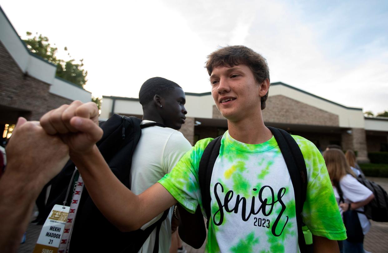 Students at Lincoln High School fist bump a Leon County Schools employee ahead of the start of the first day of school on Wednesday, Aug. 10, 2022 in Tallahassee, Fla. 