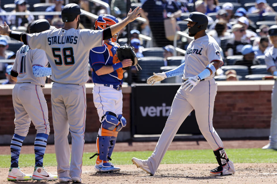 Miami Marlins' Jerar Encarnacion, front right, celebrates with Jacob Stallings (58) and Miguel Rojas (11) after hitting a grand slam against New York Mets relief pitcher Seth Lugo during the seventh inning of a baseball game, Sunday, June 19, 2022, in New York. (AP Photo/Jessie Alcheh)