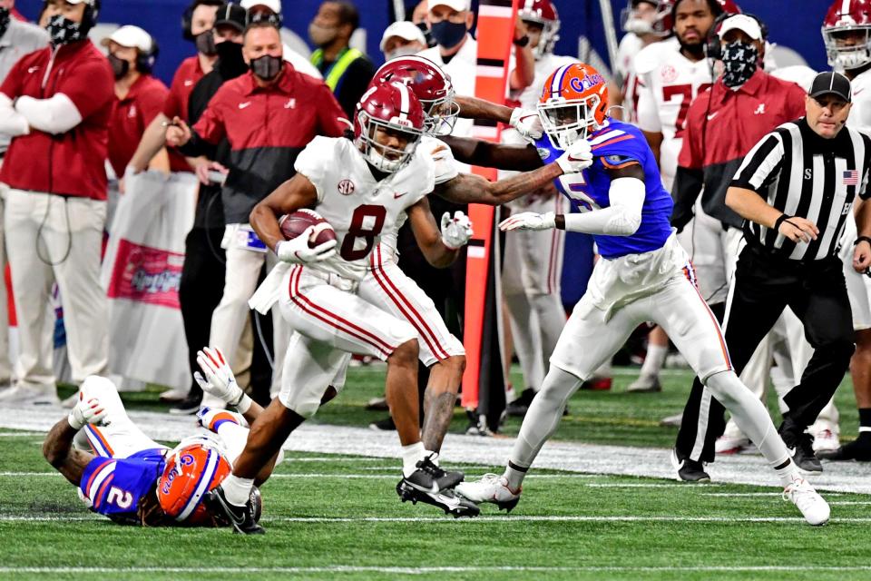 Alabama wide receiver John Metchie III avoids Florida defenders after making a catch during the third quarter in the 2020 SEC championship game at Mercedes-Benz Stadium in Atlanta.