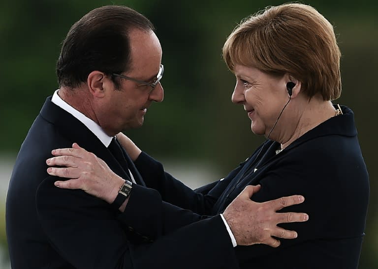 French President Francois Hollande (L) embraces German Chancellor Angela Merkel during a remembrance ceremony to mark the centenary of the battle of Verdun, at the Douaumont Ossuary (Ossuaire de Douaumont), northeastern France, on May 29, 2016