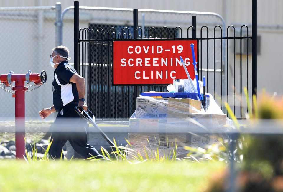 A man delivers cleaning equipment to a coronavirus screening clinic at Parklands Christian College in Logan, south of Brisbane.