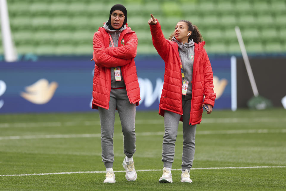 Morocco's Nouhaila Benzina, left, and Fatima Gharbi walk around the ground during a familiarization tour ahead of their Women's World Cup Group H match against Germany in Melbourne, Australia, Sunday, July 23, 2023. When Benzina steps onto the pitch Monday evening, she will be first player to compete in a senior-level FIFA Women's World Cup wearing a hijab. (AP Photo/Victoria Adkins)