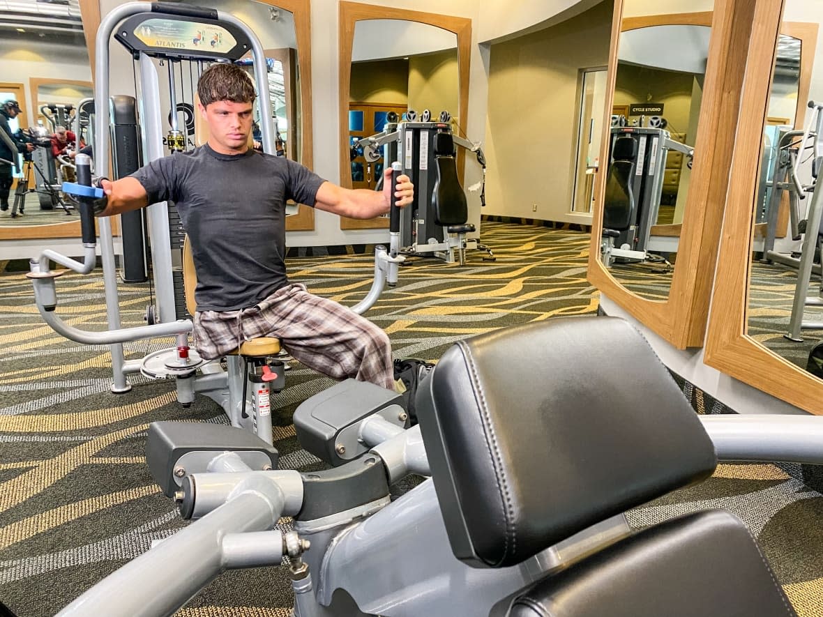 Emilio Dutra works out at a Movati Athletic gym in Ottawa on March 14, 2023. The 23-year-old, who lost his leg and four fingers in a boating incident as a teenager, has recently been featured as a model for clothing retailer Lululemon. (Stu Mills/CBC - image credit)