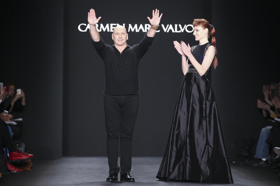 Designer Carmen Marc Valvo, left, acknowledges the crowd alongside model Taylor Foster after his fall 2014 collection is modeled during Fashion Week, Friday, Feb. 7, 2014, in New York. (AP Photo/John Minchillo)