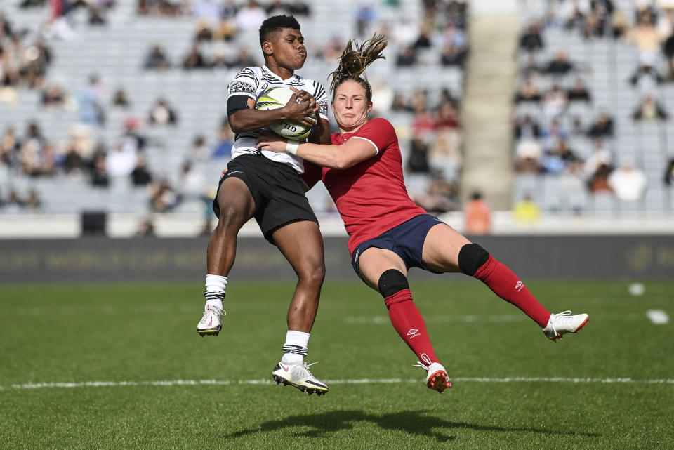 Vitalina Naikore, left, of Fiji and Lydia Thompson of England compete for the ball during the Women's Rugby World Cup pool match between England and Fiji, at Eden Park, Auckland, New Zealand, Saturday, Oct.8. 2022. (Andrew Cornaga/Photosport via AP)