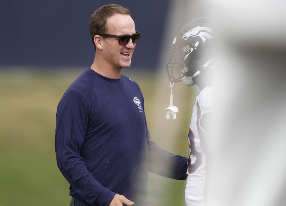 Retired Denver Broncos quarterback Peyton Manning greets former teammate Von Miller during a combined NFL football training camp with the San Francisco 49ers at the Broncos' headquarters Friday, Aug. 16, 2019, in Englewood, Colo. (AP Photo/David Zalubowski)