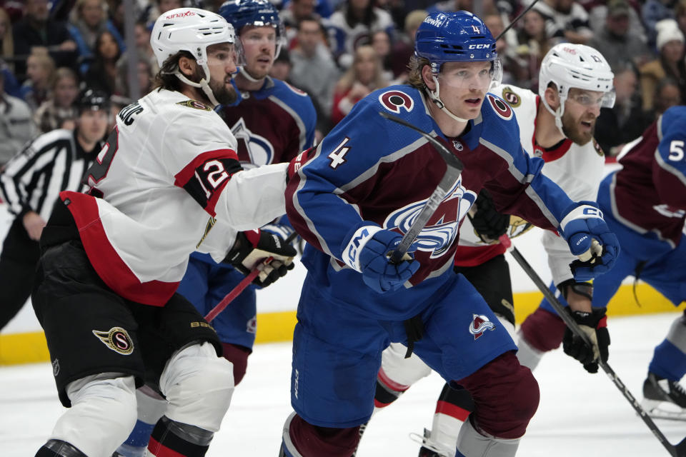 Colorado Avalanche defenseman Bowen Byram, right, andOttawa Senators center Mark Kastelic pursue the puck during the second period of an NHL hockey game Thursday, Dec. 21, 2023, in Denver. (AP Photo/David Zalubowski)