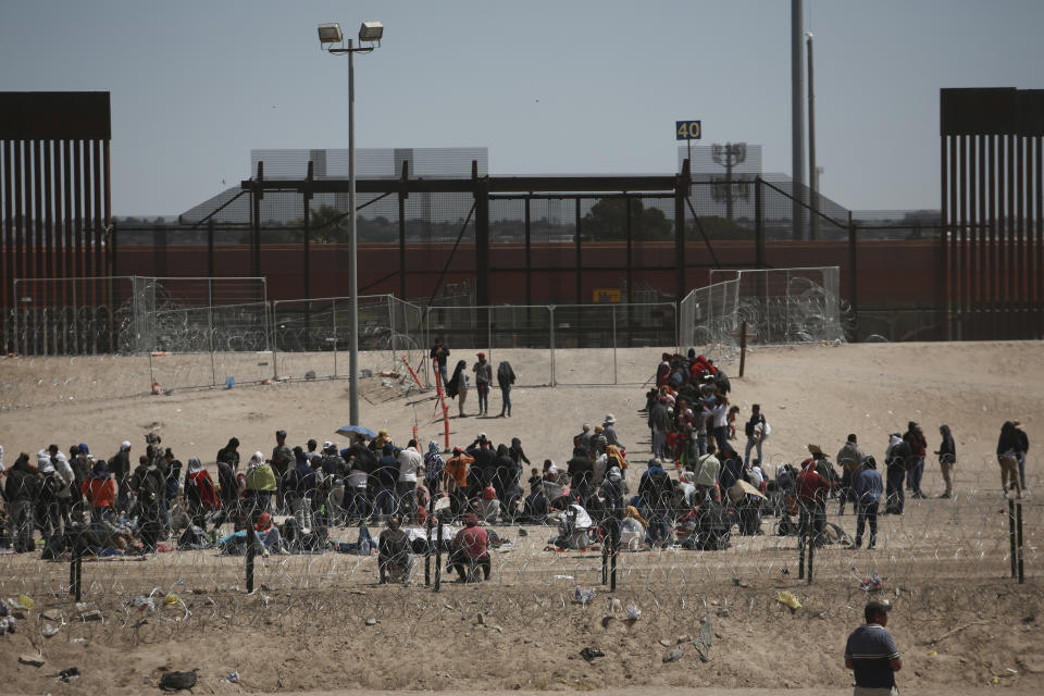 Migrants wait for U.S. authorities, between a barbed-wire barrier and the border fence at the US-Mexico border, as seen from Ciudad Juarez, Mexico, Wednesday, May 10, 2023. The U.S. on May 11 will begin denying asylum to migrants who show up at the U.S.-Mexico border without first applying online or seeking protection in a country they passed through, according to a new rule released on May 10. (AP Photo/Christian Chavez)