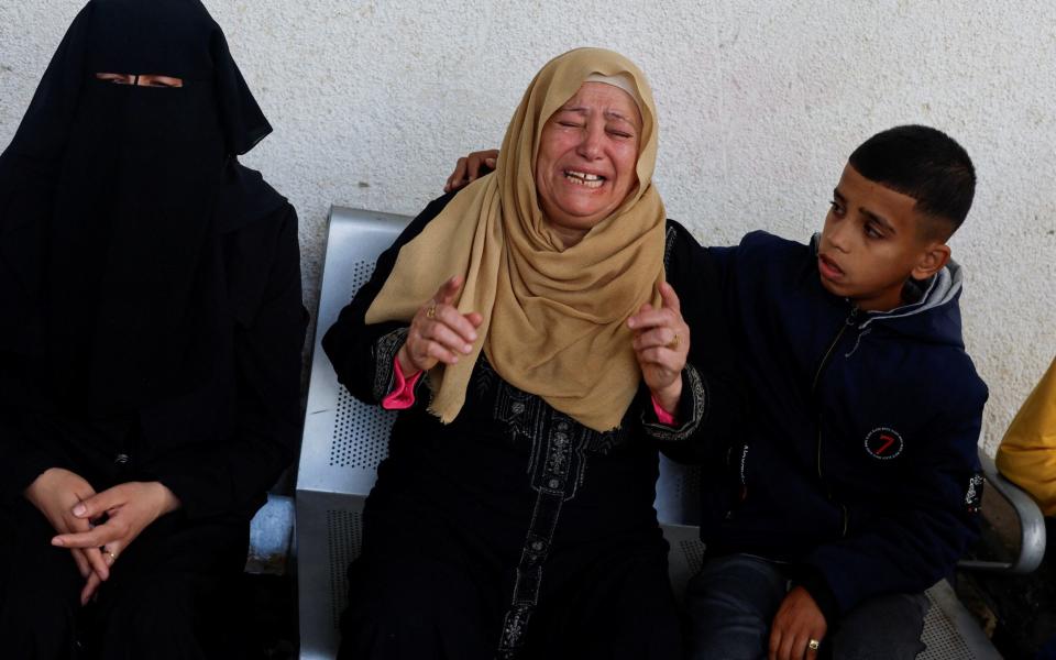 Mourners react near the bodies of Palestinians (not pictured) killed in Israeli strikes