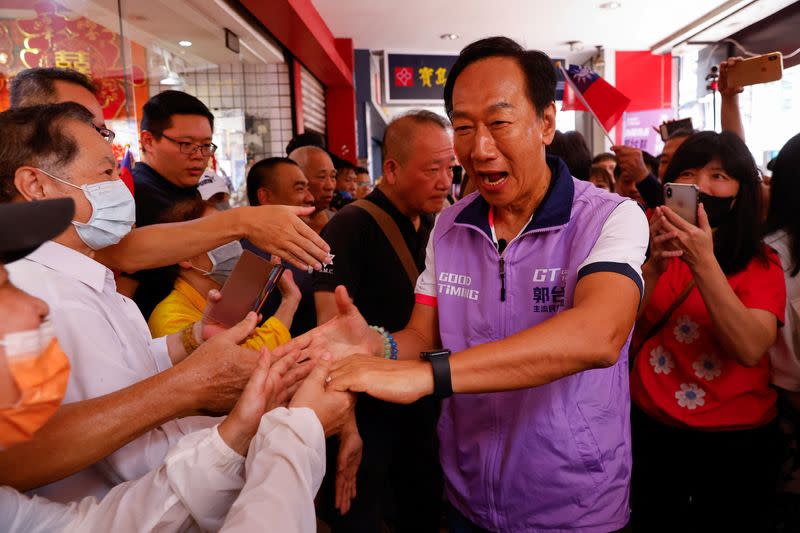 Foxconn founder Terry Gou shakes hands with his supporters at one of his signature campaign offices in New Taipei City