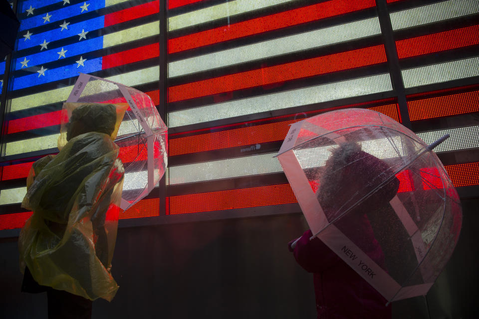 Les touristes se protègent de la pluie battante à Times Square alors que l'ouragan Sandy s'approche à New York le 29 octobre 2012. L'ouragan Sandy a commencé lundi à frapper la côte est des États-Unis avec des vents violents et une pluie battante, alors que la tempête monstre a fermé les transports, fermé les entreprises et envoyé des milliers de personnes se précipiter vers des terrains plus élevés pendant des heures avant que le pire ne soit dû à la grève.  REUTERS/Andrew Kelly (ÉTATS-UNIS - Tags: ENVIRONNEMENT CATASTROPHE IMAGES TPX DU JOUR)