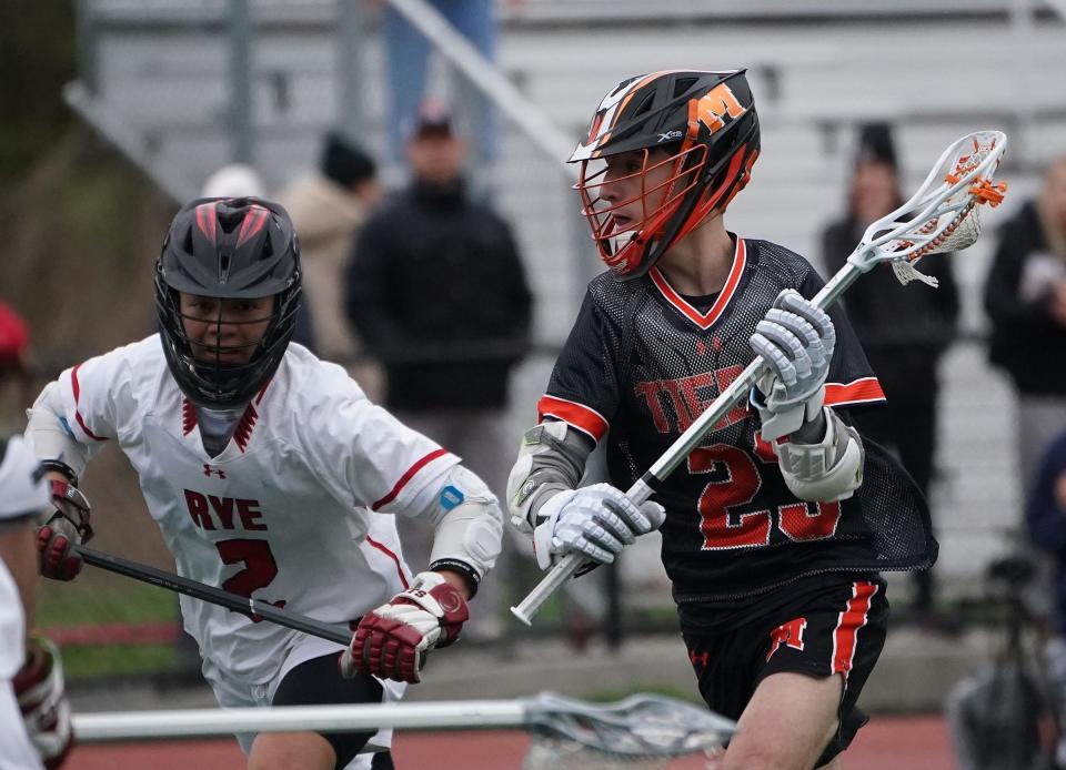 Mamaroneck's Jared Rabina (23) works the ball around Rye's Joe Chai (2) during their 9-7 win in boys lacrosse at Rye High School. Thursday, April 18, 2024.
