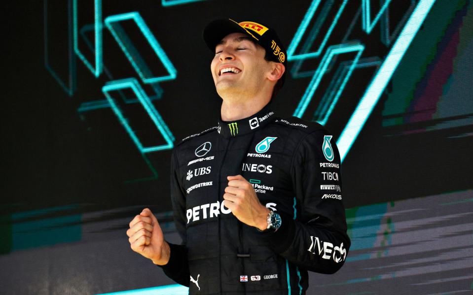 Race winner George Russell of Great Britain and Mercedes celebrate on the podium after the Brazilian Grand Prix