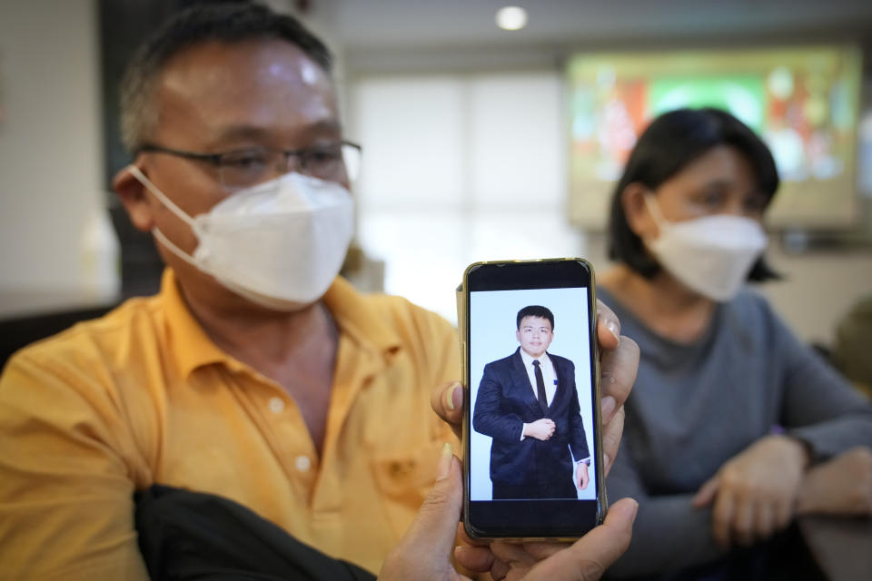 Goi Chee Kong shows a picture of his son Goi Zhen Feng, who died after falling prey to human trafficking syndicates, during a press conference in Petaling Jaya, outskirts of Kuala Lumpur, Malaysia, Wednesday, Sept. 21, 2022. The parents of Goi Zhen Feng appealed Wednesday to the government to rescue other scam victims trapped in Myanmar and Cambodia, saying he hoped there would be no more fatalities. (AP Photo/Vincent Thian)