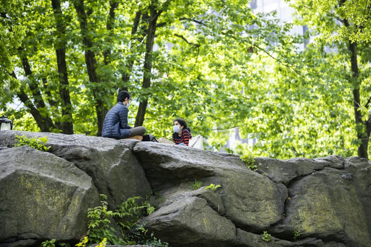 <span class="caption">Central Park, New York City, on Memorial Day weekend, May 24, 2020. </span> <span class="attribution"><a class="link " href="https://www.gettyimages.com/detail/news-photo/on-memorial-day-weekend-a-man-and-woman-with-masks-practice-news-photo/1226848754?adppopup=true" rel="nofollow noopener" target="_blank" data-ylk="slk:Ira L. Black/Corbis via Getty Images;elm:context_link;itc:0;sec:content-canvas">Ira L. Black/Corbis via Getty Images</a></span>