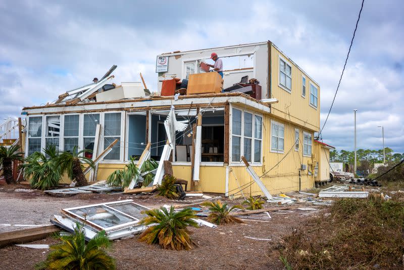 JJ McNelis tries to recover some items from his building after Hurricane Sally swept through, at Perdido Key, Florida
