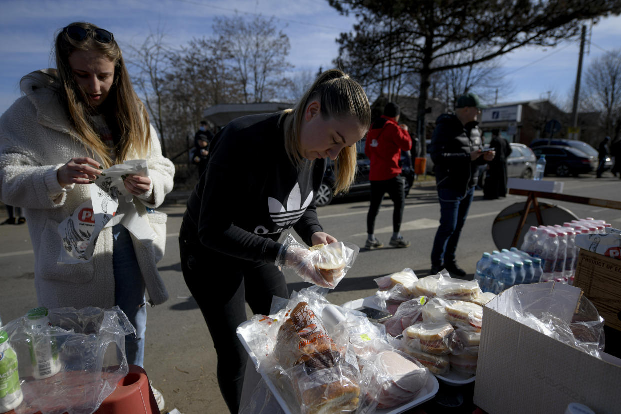 Volunteers prepare sandwiches for refugees crossing the border from Ukraine at the Romanian-Ukrainian border, in Siret, Romania, Friday, Feb. 25, 2022. (AP Photo/Andreea Alexandru, File)