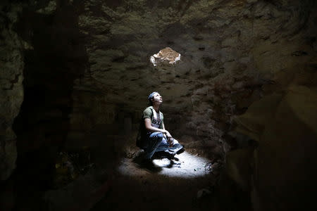 A man looks at an opening from a makeshift shelter in an underground cave in Idlib, Syria September 3, 2018. Picture taken September 3, 2018. REUTERS/Khalil Ashawi