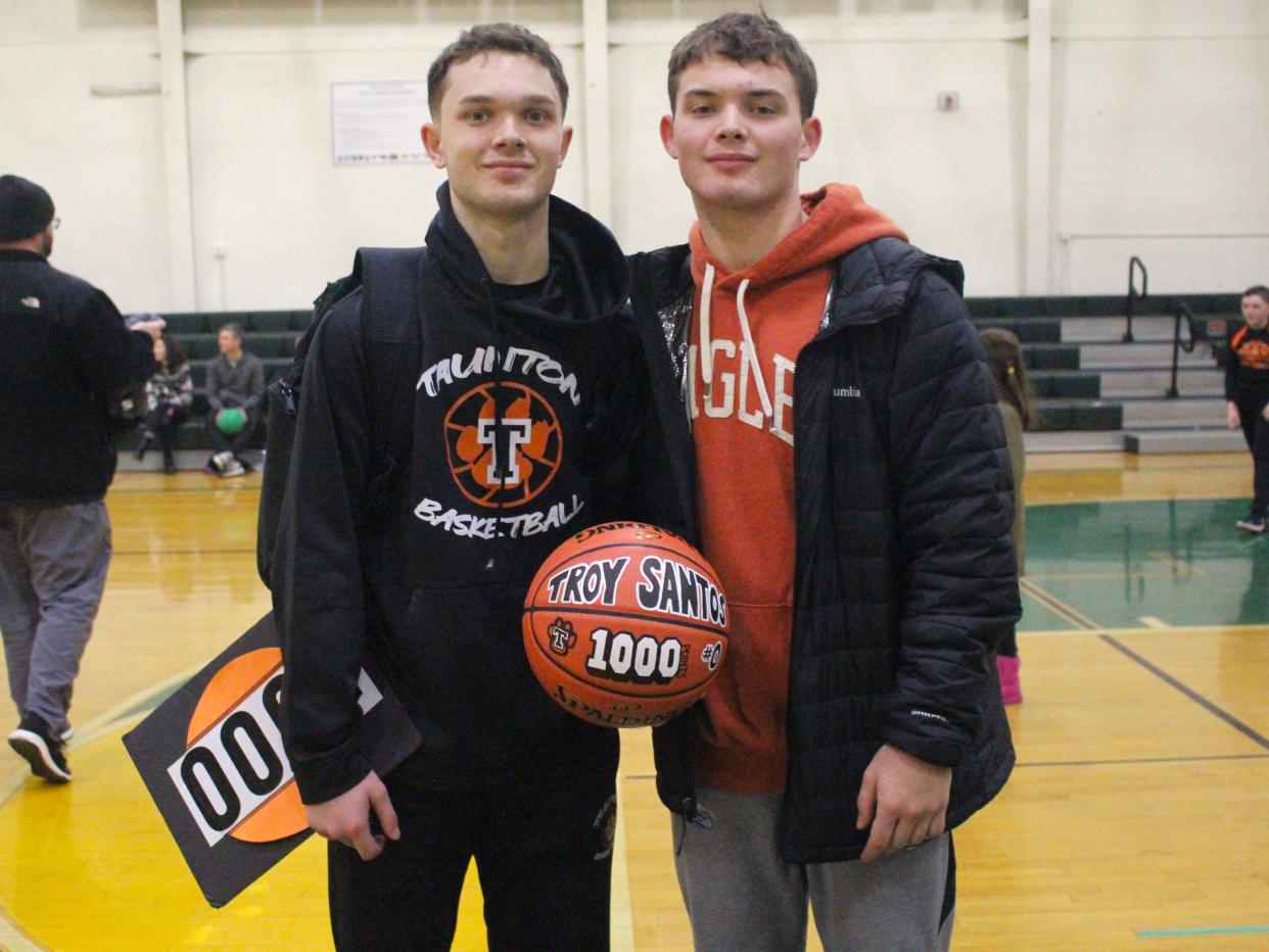 Taunton's Troy Santos (left), holding the game ball for his 1,000th varsity point, poses with older brother Trent Santos following a Hockomock League game against King Philip.