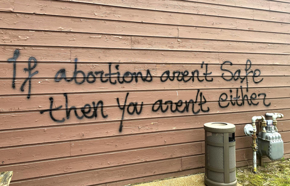 Threatening graffiti is seen on the exterior of Wisconsin Family Action offices in Madison, Wis., on Sunday, May 8, 2022. The Madison headquarters of the anti-abortion group was vandalized late Saturday or early Sunday, according to an official with the group. (Alex Shur/Wisconsin State Journal via AP)