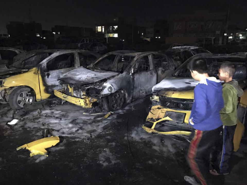 Civilians gather at the site of a car bomb in a used car dealer's parking lot in the southwestern al-Bayaa neighborhood, Baghdad, Iraq, Thursday, Feb. 16, 2017. (AP Photo/ Ali Abdul Hassan)