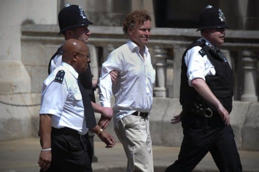 A man is led away by police officers outside the High Court in London on May 28 after he burst into the chamber where the Leveson Inquiry was hearing evidence from former British prime minister Tony Blair. Blair told a press ethics inquiry Monday that he got too close to Rupert Murdoch's media empire, in evidence disrupted by the protester who called him a "war criminal"