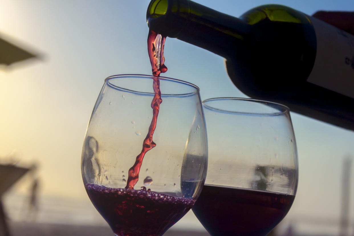 Activities on the sunset. bottle of wine serving wine on two cups on the beach