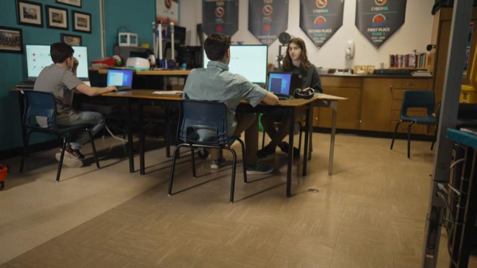 The three-person team called the CyberDragons works out of their technology teacher's classroom. Around them, banners reminiscent of past CyberTitan competitions drape the walls. 
