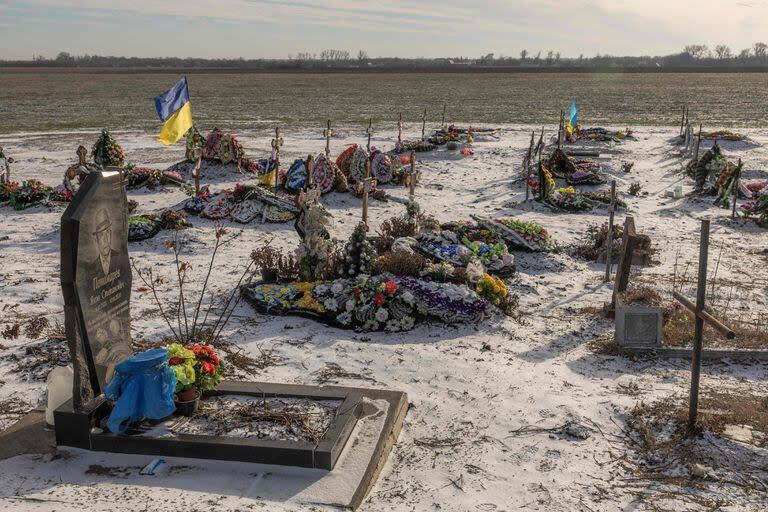 Esta fotografía tomada el 23 de enero de 2024 muestra tumbas, la mayoría de las cuales son de las víctimas asesinadas durante el ataque ruso del año pasado a una tienda y cafetería en el pueblo de Groza, región de Kharkiv, en medio de la invasión rusa de Ucrania.