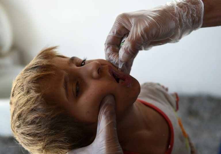 An Afghan refugee child receives a polio vaccination at the United Nations High Commissioner for Refugees (UNHCR) camp on the outskirts of Kabul, upon returning from Pakistan