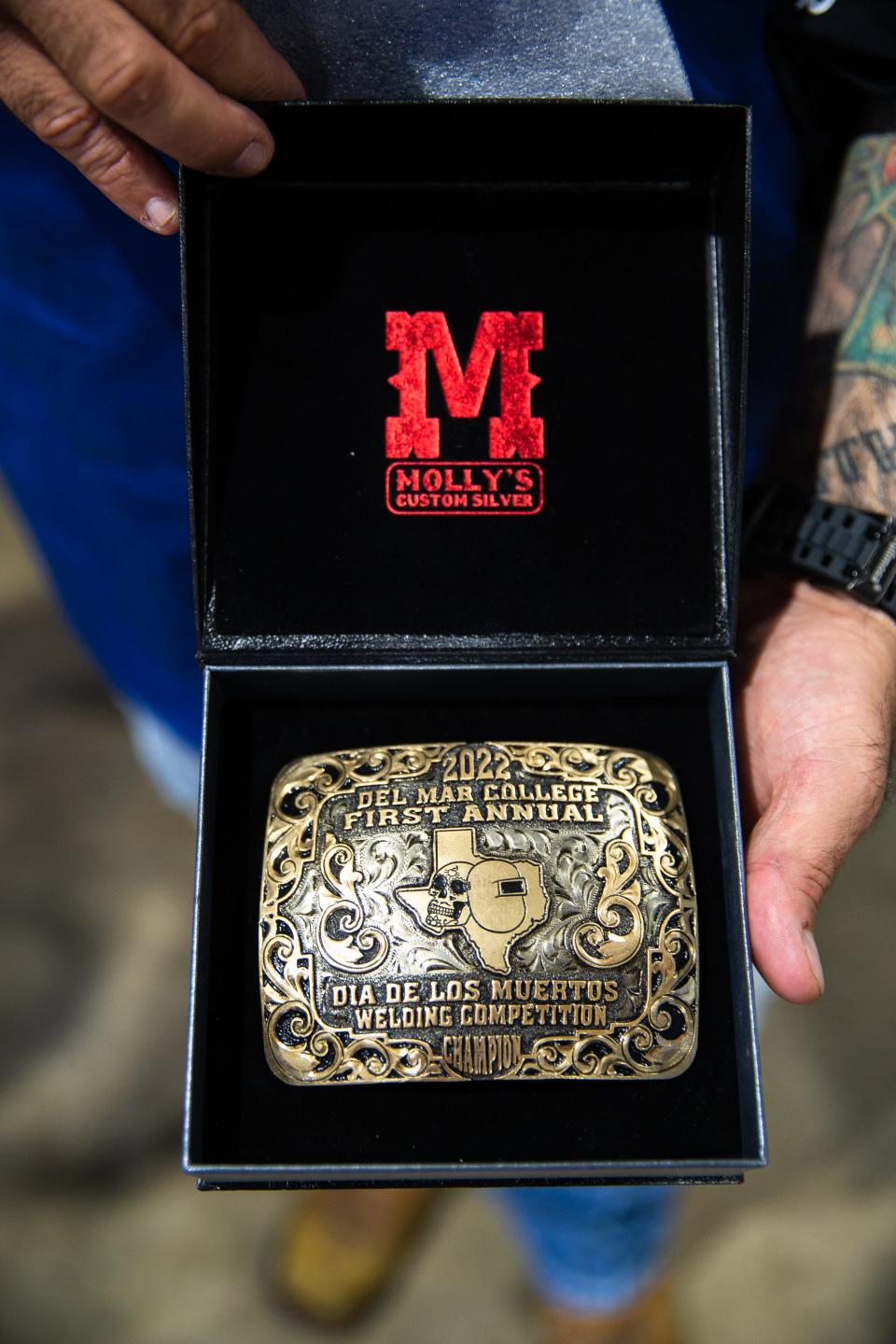 Samuel Garcia, Del Mar College assistant professor of welding applied technology, displays a belt buckle award at the school's Día de los Muertos Welding Competition, an event he organized, on Friday, Nov. 4, 2022, in Corpus Christi, Texas.