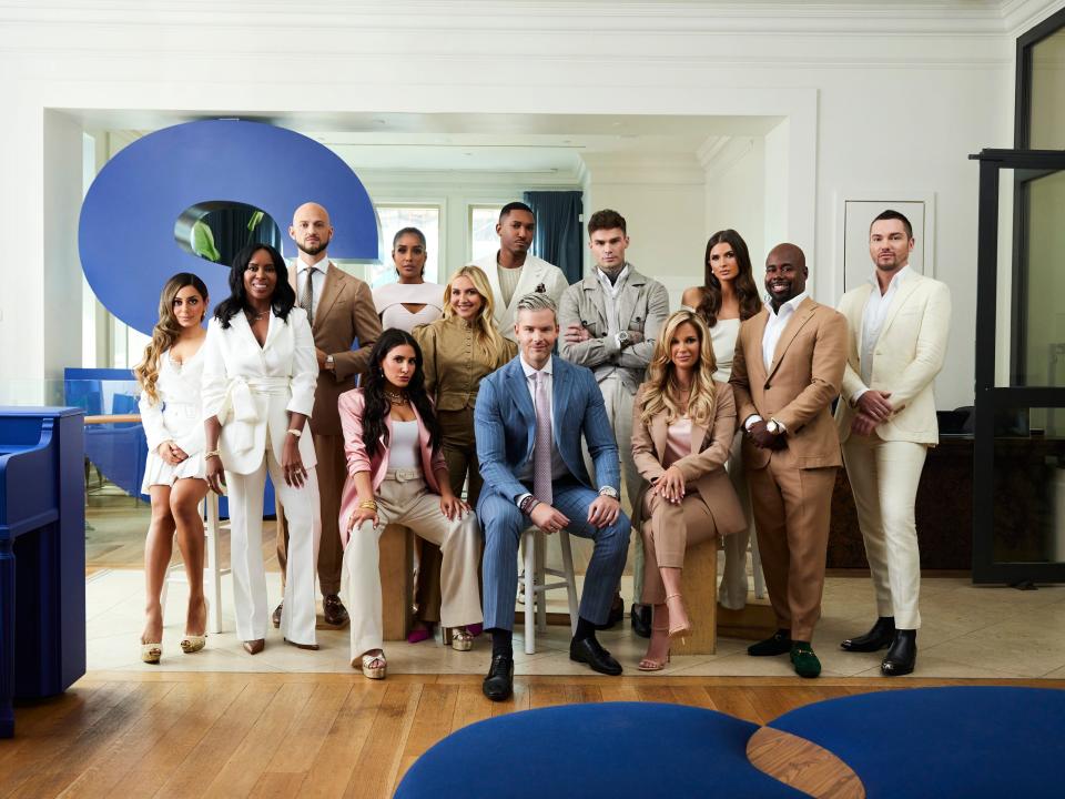 The cast of "Owning Manhattan" pose for a group photo in the sleek SERHANT headquarters in Soho.
