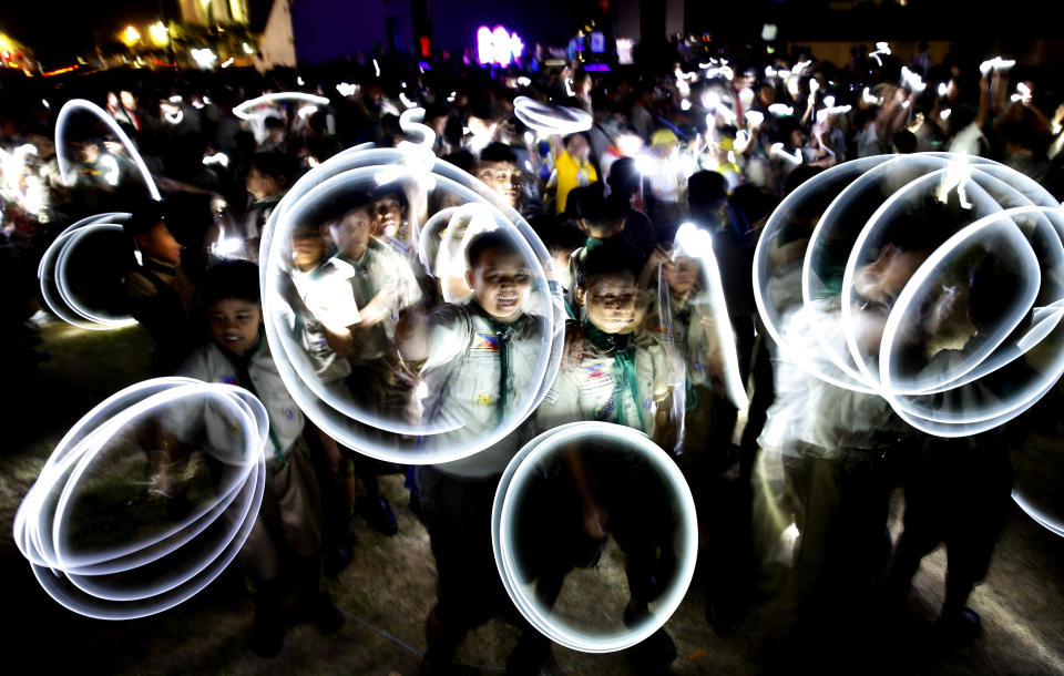 In this Saturday, March 30, 2019, file photo, Philippine Boy Scouts play with their flashlights at the countdown for the 12th Earth Hour event in suburban Makati city, east of Manila, Philippines. Earth Hour is the symbolic switching off of the lights for one hour to help minimize fossil fuel consumption as well as mitigate the effects of climate change. (AP Photo/Bullit Marquez, File)