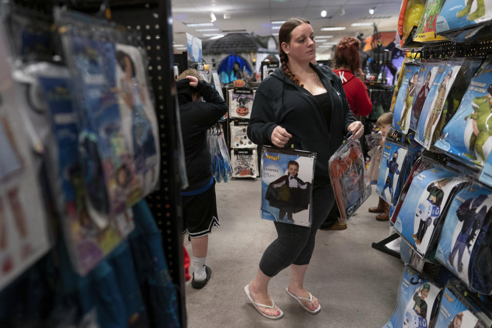 Jesse Johnson shops for Halloween costumes with her children at Spirit Halloween in Findlay, Ohio, Friday, Oct. 20, 2023. Earlier this year, Johnson started a job with the Family Resource Center, the same organization that employed the peer support worker who was so instrumental in her own early recovery. (AP Photo/Carolyn Kaster)
