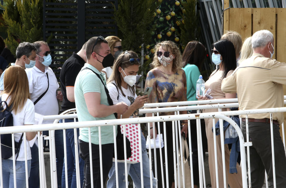 People wait in line to enter the COVID-19 vaccination center, at A1 Arena in Skopje, North Macedonia, on Tuesday, May 4, 2021. The European Union started delivering EU-funded coronavirus vaccines Tuesday to the Balkans, a region that wants to join the 27-nation bloc but where China and Russia have already been supplying the much-needed shots and making political gains. (AP Photo/Boris Grdanoski)