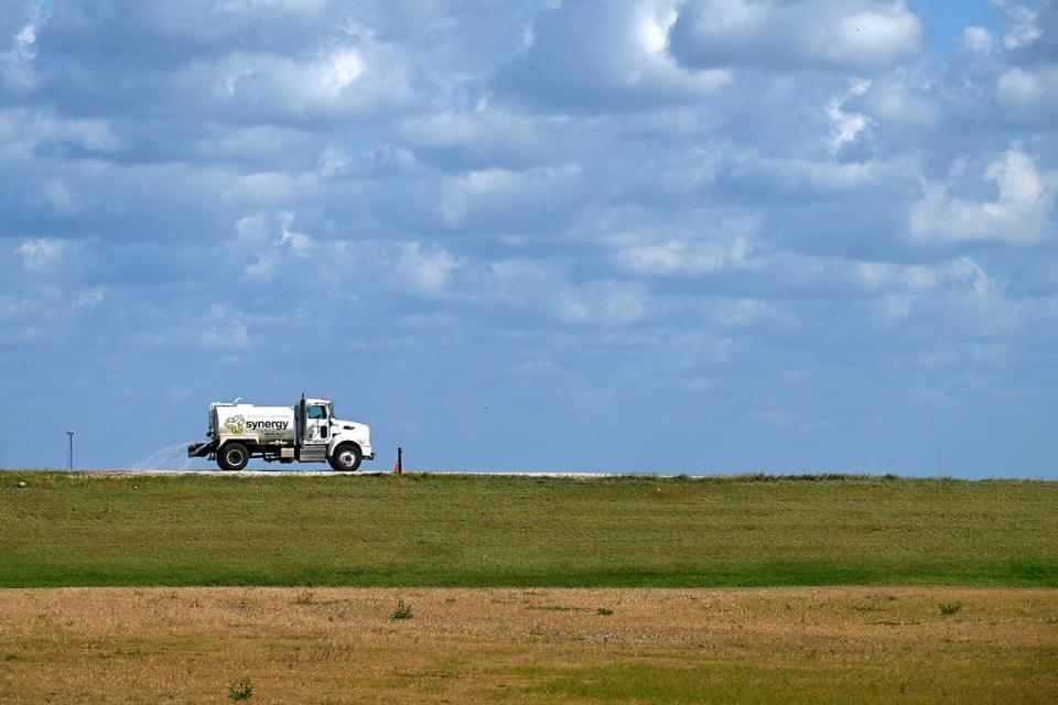 Operadores de Piney Point anunciaron recientemente un hito con el cierre del compartimento Old Gypsum Stack-South, uno de los cuatro estanques que deben cerrarse en la antigua planta de procesamiento de fosfatos. Un camión cisterna rocía el camino de tierra que rodea a la pila.