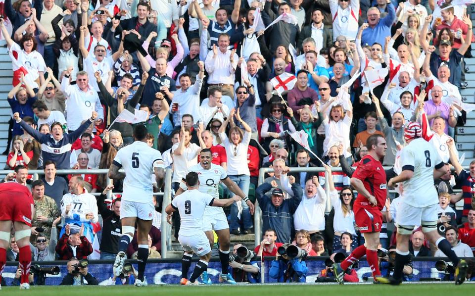 England's Luther Burrell, center, celebrates with his teammates after scoring a try against Wales during the Six Nations Rugby Union match between England and Wales at Twickenham stadium in London Sunday, March, 9, 2014. (AP Photo/Alastair Grant)