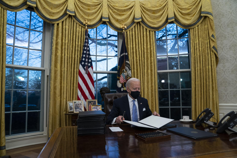 FILE - In this Jan. 20, 2021, file photo President Joe Biden signs a series of executive orders in the Oval Office of the White House in Washington. (AP Photo/Evan Vucci, File)