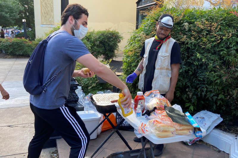A protester grabs a mustard bottle at a sidewalk barbecue in Washington