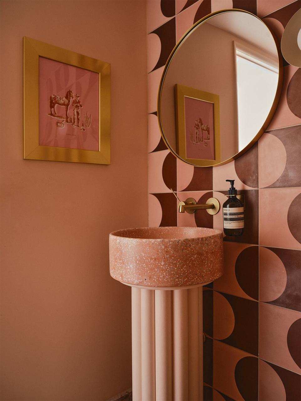 <u>Strands Del Sol Arch Pink + Russet Cement Tile</u> and <u>Bondi Millennial Pink Sink</u>, Concrete Collaborative; Circle Brass Mirror, <u>Rejuvenation</u>; Marfa Cowboy Print by <u>Katie Kime</u>.