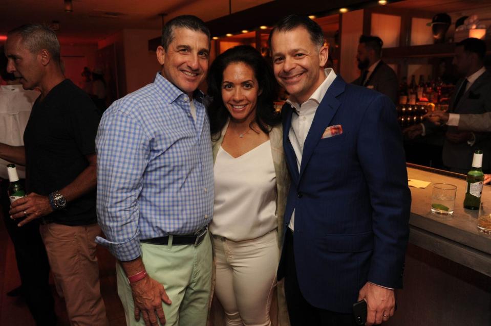 Cathy Tusiani in the centre with her husband, Michael Tusiani on the right at a  Miami Beach party in 2017 (Startraks/Shutterstock)