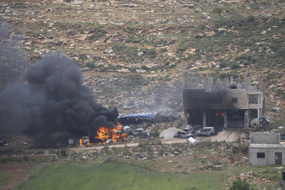 Properties of Palestinian villagers are set on fire by Israeli settlers in the West Bank village of al-Mughayyir, Saturday, April 13, 2024. Israel's army says the body of a missing Israeli teen has been found in the occupied West Bank after he was killed in a "terrorist attack." The disappearance of 14-year-old Binyamin Achimair sparked a large attack by settlers on a Palestinian village on Friday and Saturday. (AP Photo/Nasser Nasser)