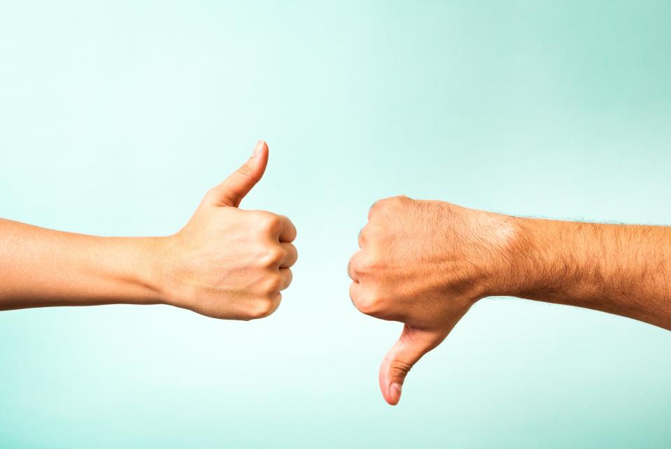 one hand giving a thumbs-up and another giving a thumbs-down